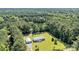 Aerial view of a home in the woods with manicured lawns and a detached garage with long driveway at 203 Warbler St., Georgetown, SC 29440