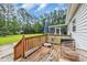 The outdoor deck features wood railing and steps with patio furniture and a grill overlooking a lush green yard at 203 Warbler St., Georgetown, SC 29440
