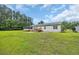 Sprawling backyard featuring a spacious lawn, the back of the home and deck, and surrounding woods for privacy at 203 Warbler St., Georgetown, SC 29440