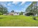 Wide open backyard featuring lush lawn, the back of the home and deck, and a large metal garage at 203 Warbler St., Georgetown, SC 29440