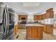 Well-lit kitchen boasts stainless steel appliances, wooden cabinets, and a central island at 203 Warbler St., Georgetown, SC 29440