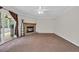 Cozy living room features a stone fireplace, ceiling fan, and sliding glass doors at 203 Warbler St., Georgetown, SC 29440