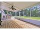 Relaxing screened-in porch with wood flooring, fan, and picturesque backyard views at 203 Warbler St., Georgetown, SC 29440