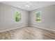 Corner bedroom with wood-look floors, ceiling fan, and natural light from the two windows at 204 Elm St., Johnsonville, SC 29555