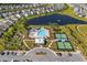 Aerial view of community amenities: pool, tennis courts, parking and a lake with fountain; all surrounded by lush landscaping at 205 Threshing Way # 1052, Myrtle Beach, SC 29579