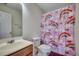 Bathroom with wood vanity, a toilet and rainbow shower curtain at 205 Threshing Way # 1052, Myrtle Beach, SC 29579