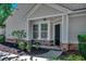 Charming front porch with stylish black door, stone accents, and fresh landscaping at 205 Threshing Way # 1052, Myrtle Beach, SC 29579