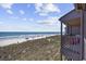 Charming balcony view overlooking sandy beach, inviting ocean waters, and grassy dunes at 208 Ocean Blvd. N # 324, North Myrtle Beach, SC 29582