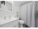 This bathroom features a white vanity, a toilet, shower curtain, and beach themed decor at 208 Ocean Blvd. N # 324, North Myrtle Beach, SC 29582