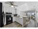 Modern kitchen with black appliances and white cabinets, open to the living area at 208 Ocean Blvd. N # 324, North Myrtle Beach, SC 29582