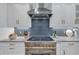 Stylish kitchen showcasing a professional gas range, custom hood, and modern backsplash at 2150 North Berwick Dr., Myrtle Beach, SC 29575