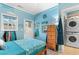 Coastal bedroom with light-blue walls, wooden dresser, and convenient washer-dryer at 230 Addison Cottage Way, Murrells Inlet, SC 29576