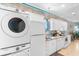 Bright kitchen includes white cabinets, stainless appliances and washer-dryer combo at 230 Addison Cottage Way, Murrells Inlet, SC 29576