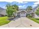 Charming home with an attached garage and a well-manicured lawn with mature trees and a long concrete driveway at 232 Je Edward Dr. # 19, Myrtle Beach, SC 29588