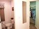 Half-bathroom with toilet and decorative mirror leading to closet with rod for hanging clothes at 250 Nature Trail, Little River, SC 29566