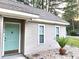 A charming turquoise front door offers a welcoming contrast against the neutral siding and manicured garden at 250 Nature Trail, Little River, SC 29566
