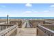 Beach access wooden walkway through sandy dunes leading to a stunning ocean view on a clear day at 2500 N Ocean Blvd. # 601, Myrtle Beach, SC 29577