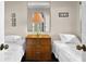 Cozy bedroom with twin beds, dark-wood three-drawer dresser and mirror, and charming seaside-themed artwork at 2500 N Ocean Blvd. # 601, Myrtle Beach, SC 29577