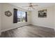 This bedroom features woodgrain floors, a ceiling fan, a window with curtains, and beige walls at 278 Carolina Crossing Blvd., Little River, SC 29566
