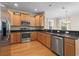 Well-lit kitchen with stainless steel appliances, wooden cabinets, granite countertops, and hardwood flooring at 278 Carolina Crossing Blvd., Little River, SC 29566