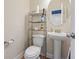 Cozy powder room with a pedestal sink, wood floors, and toilet with metal shelving at 278 Carolina Crossing Blvd., Little River, SC 29566