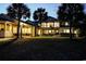 Elegant home exterior with a spacious lawn, inviting patio, and sophisticated outdoor lighting at twilight at 2790 Fowler Rd., Loris, SC 29569