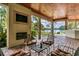 Cozy outdoor living space with a fireplace, TV, and comfortable seating overlooking the beautiful lake at 2790 Fowler Rd., Loris, SC 29569
