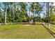 Spacious pasture with white fencing, mature trees, and a grazing horse in a peaceful rural setting at 2790 Fowler Rd., Loris, SC 29569