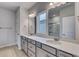 Bathroom featuring dual sinks, quartz countertop, framed mirrors, and a glass enclosed shower at 307 Dunlin Pl, Conway, SC 29526