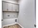 Functional laundry room with wood-look floors and gray cabinets for ample storage space at 307 Dunlin Pl, Conway, SC 29526