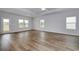Bright living room with wood-look floors, ceiling fan, and natural light from the three rear windows at 307 Dunlin Pl, Conway, SC 29526