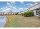 A serene backyard view featuring a calm lake, grassy lawn, and well-maintained condo buildings at 310 Kiskadee Loop # D, Conway, SC 29526