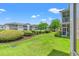 Scenic backyard view with lush green lawn, manicured shrubs, and community buildings at 3104 Sweetwater Blvd. # 3104, Murrells Inlet, SC 29576