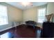 A versatile room has hardwood floors, natural light from two windows, and a gray futon at 3180 Long Avenue Ext., Conway, SC 29526