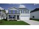 Two-story home features a two-car garage, stone accents, and a manicured lawn at 335 Garden Grove St, Conway, SC 29526