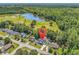 Aerial view of a home near a pond, surrounded by lush green trees, denoted by a red map pin at 340 Boxcar Dr., Longs, SC 29568