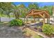 Landscaped backyard showcasing a wooden gazebo, green bushes, and a white fence at 340 Boxcar Dr., Longs, SC 29568