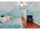 View of bedroom with light-blue walls, ceiling fan, a navy chair, and hardwood floors at 340 Boxcar Dr., Longs, SC 29568