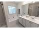 Bright bathroom featuring double sinks, white cabinetry, and a separate tub and shower area for convenience at 359 Harbour Reef Dr., Myrtle Beach, SC 29588