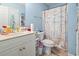 Well-lit bathroom featuring blue walls, white vanity, and nautical themed shower curtain at 3676 Clay Pond Village Ln. # 4, Myrtle Beach, SC 29579