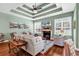 Bright living room featuring hardwood floors, a fireplace, and a tray ceiling with a fan at 3736 Kingsley Dr., Myrtle Beach, SC 29588