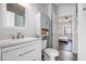 Bright and airy bathroom with sleek vanity and a view into the main bedroom with its warm wood-look flooring at 3939 Gladiola Ct. # 202, Myrtle Beach, SC 29588
