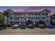Three-story condo building with white balconies and stairs, and multiple parked cars at 3939 Gladiola Ct. # 202, Myrtle Beach, SC 29588