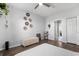 Spacious main bedroom has wood floors, a ceiling fan, a charming wall art, and a glimpse into the bright en-suite bathroom at 3939 Gladiola Ct. # 202, Myrtle Beach, SC 29588
