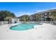 Resort-style pool and sundeck surrounded by lush greenery and well-maintained buildings at 3939 Gladiola Ct. # 202, Myrtle Beach, SC 29588