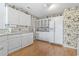 Bright kitchen featuring white cabinets, floral wallpaper, and modern appliances providing ample storage at 4012 Grousewood Dr., Myrtle Beach, SC 29588
