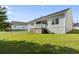 Backyard showcasing a wooden deck, patio, lush green grass, and light siding at 417 Grain Field Dr., Georgetown, SC 29440