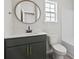 Bathroom features dark vanity, white countertop, round mirror, toilet, and shower at 417 Grain Field Dr., Georgetown, SC 29440