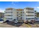 Multi-story condo building with beachside vibe, showcasing multiple units with screened-in porches and ample parking at 4350 Intercoastal Dr. # 2408, Little River, SC 29566