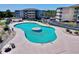 Aerial view of a large community pool surrounded by lounge chairs and well-maintained landscaping at 4350 Intercoastal Dr. # 2408, Little River, SC 29566